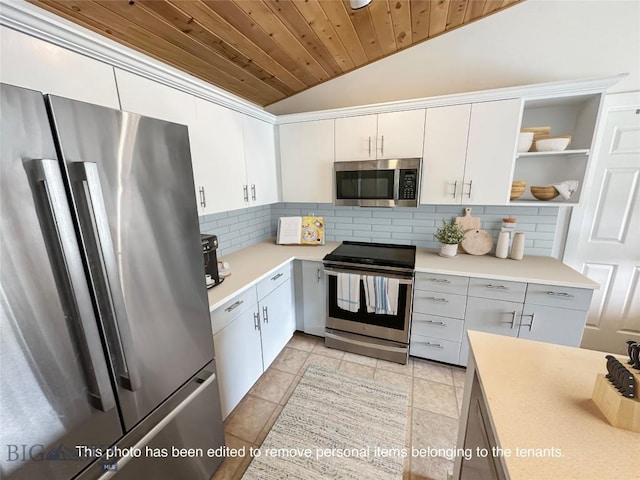 120 Firelight Dr Unit C15, Big Sky, MT 59716 - kitchen with stainless steel appliances, lofted ceiling, open shelves, light countertops, and tasteful backsplash