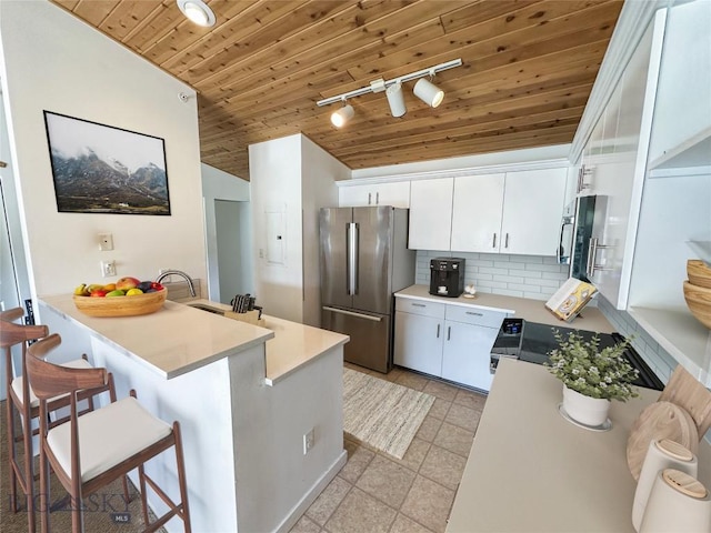 120 Firelight Dr Unit C15, Big Sky, MT 59716 - kitchen featuring high end fridge, wooden ceiling, tasteful backsplash, a peninsula, and stove