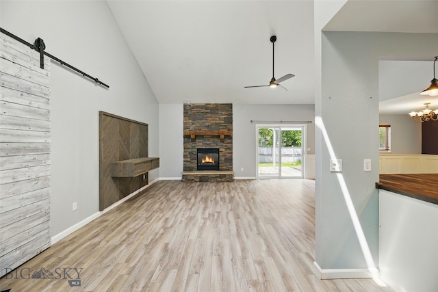 1205 Brentwood, Bozeman, MT 59718 - unfurnished living room with a barn door, a ceiling fan, high vaulted ceiling, wood finished floors, and a fireplace