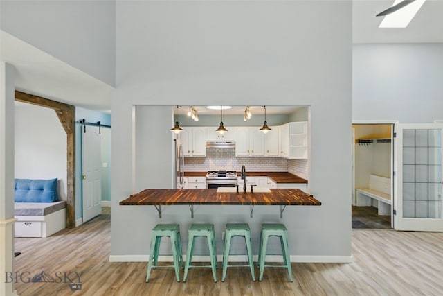 1205 Brentwood, Bozeman, MT 59718 - kitchen featuring butcher block counters, a barn door, a kitchen bar, appliances with stainless steel finishes, and a sink