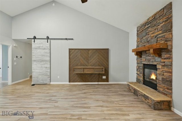1205 Brentwood, Bozeman, MT 59718 - unfurnished living room featuring a barn door, high vaulted ceiling, a fireplace, wood finished floors, and baseboards