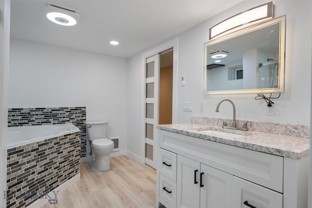 411 W 7th St, Anaconda, MT 59711 - full bath featuring toilet, vanity, wood finished floors, a relaxing tiled tub, and baseboards