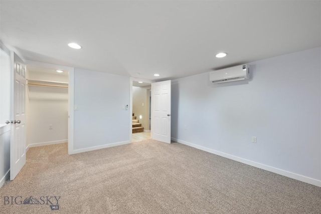 411 W 7th St, Anaconda, MT 59711 - unfurnished bedroom featuring an AC wall unit, recessed lighting, light colored carpet, baseboards, and a walk in closet