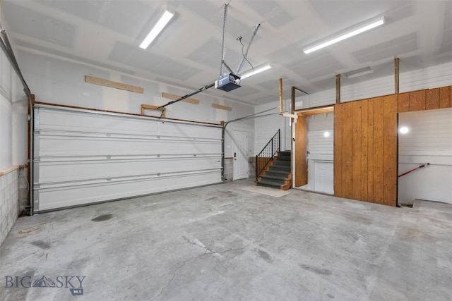 411 W 7th St, Anaconda, MT 59711 - garage with a garage door opener and wood walls