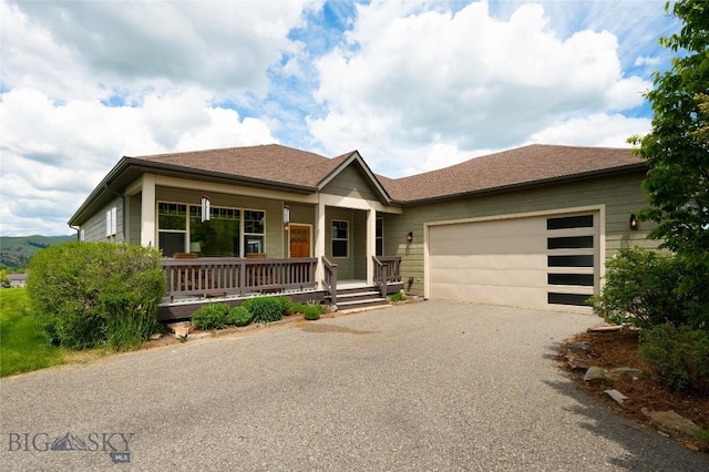 15 Blue Grouse Ct, Bozeman, MT 59715 - view of front of property with asphalt driveway, covered porch, a garage, and roof with shingles