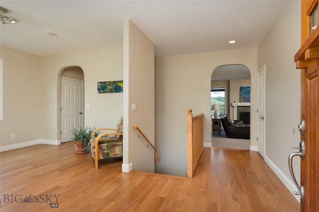 15 Blue Grouse Ct, Bozeman, MT 59715 - entrance foyer featuring arched walkways, a fireplace, light wood-style flooring, baseboards, and recessed lighting