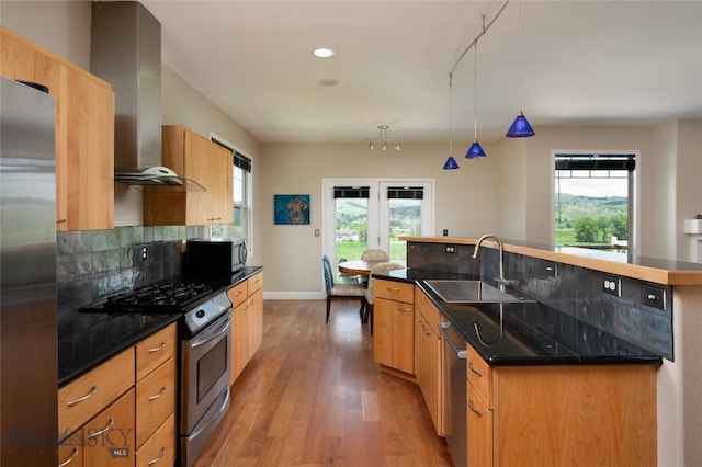 15 Blue Grouse Ct, Bozeman, MT 59715 - kitchen featuring appliances with stainless steel finishes, a sink, light wood finished floors, an island with sink, and dark countertops
