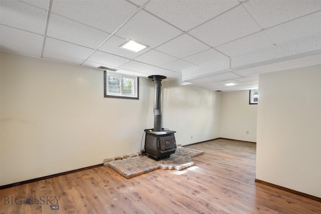303 Sharon Ct, Anaconda, MT 59711 - basement with a wood stove, baseboards, wood finished floors, and a paneled ceiling