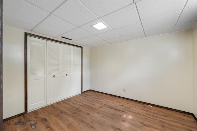 303 Sharon Ct, Anaconda, MT 59711 - unfurnished bedroom featuring wood finished floors, baseboards, a paneled ceiling, and a closet