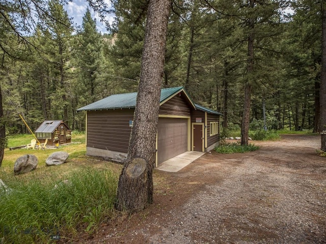 64370 Gallatin Rd, Gallatin Gateway, MT 59730 - garage featuring a view of trees and dirt driveway