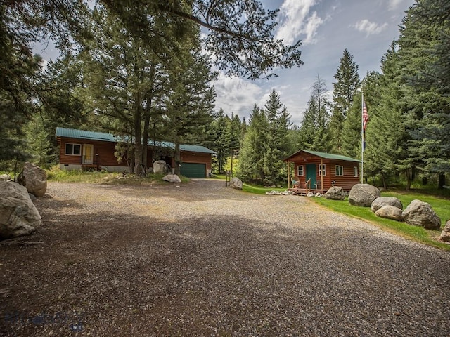 64370 Gallatin Rd, Gallatin Gateway, MT 59730 - log cabin with an outdoor structure, driveway, an attached garage, and a metal roof