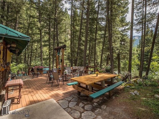 64370 Gallatin Rd, Gallatin Gateway, MT 59730 - wooden deck with outdoor dining space and a wooded view