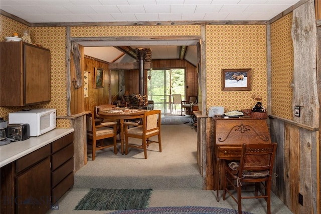 64370 Gallatin Rd, Gallatin Gateway, MT 59730 - dining space featuring carpet, wooden walls, lofted ceiling, and wallpapered walls