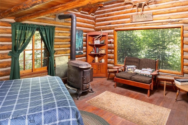 64370 Gallatin Rd, Gallatin Gateway, MT 59730 - bedroom featuring log walls, a wood stove, hardwood / wood-style floors, and a wood ceiling with exposed beams