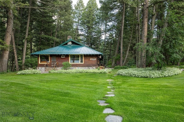 64370 Gallatin Rd, Gallatin Gateway, MT 59730 - view of front of house featuring a front yard, a metal roof, a view of trees, a porch, and a chimney