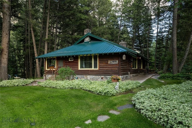 64370 Gallatin Rd, Gallatin Gateway, MT 59730 - view of side of home featuring a chimney, a metal roof, a yard, and a forest view
