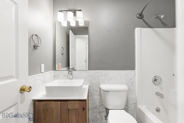85 Shallow Brook Ln, Belgrade, MT 59714 - bathroom with tile walls, vanity, a wainscoted wall, and washtub / shower combination