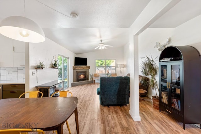 85 Shallow Brook Ln, Belgrade, MT 59714 - living area with a ceiling fan, light wood-style floors, a glass covered fireplace, and vaulted ceiling