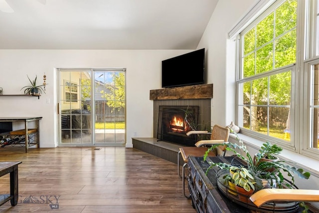 85 Shallow Brook Ln, Belgrade, MT 59714 - living area with wood finished floors, a tiled fireplace, and vaulted ceiling