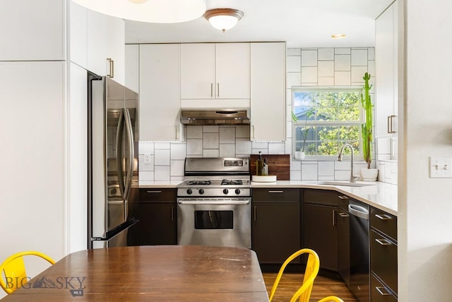 85 Shallow Brook Ln, Belgrade, MT 59714 - kitchen with appliances with stainless steel finishes, white cabinets, backsplash, under cabinet range hood, and light countertops