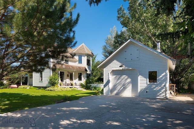 311 N 6th St, Manhattan, MT 59741 - view of front of property with a porch, a detached garage, concrete driveway, a front lawn, and an outdoor structure