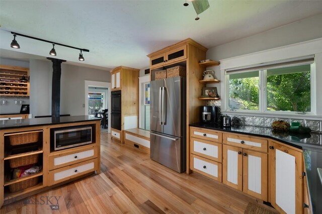 311 N 6th St, Manhattan, MT 59741 - kitchen with appliances with stainless steel finishes, rail lighting, dark countertops, open shelves, and light wood-type flooring