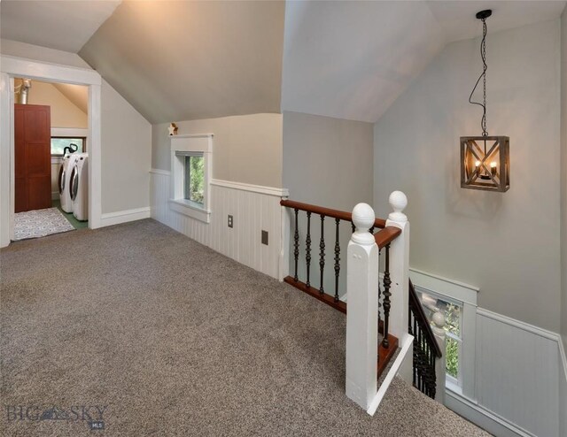 311 N 6th St, Manhattan, MT 59741 - hall with washing machine and dryer, an upstairs landing, vaulted ceiling, a wainscoted wall, and carpet flooring