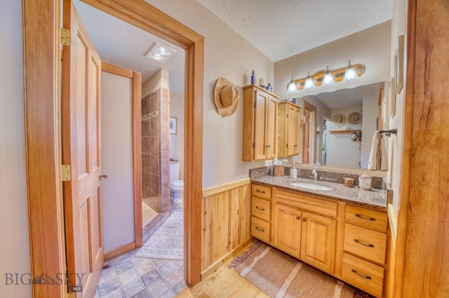886 Wierda Way, Manhattan, MT 59741 - full bathroom with vanity, a shower, wainscoting, stone finish flooring, and wooden walls