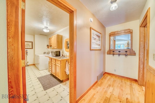 886 Wierda Way, Manhattan, MT 59741 - hallway featuring washing machine and dryer, a textured ceiling, and light flooring
