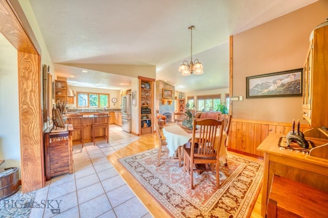 886 Wierda Way, Manhattan, MT 59741 - dining area featuring vaulted ceiling, healthy amount of natural light, wainscoting, light tile patterned flooring, and a chandelier