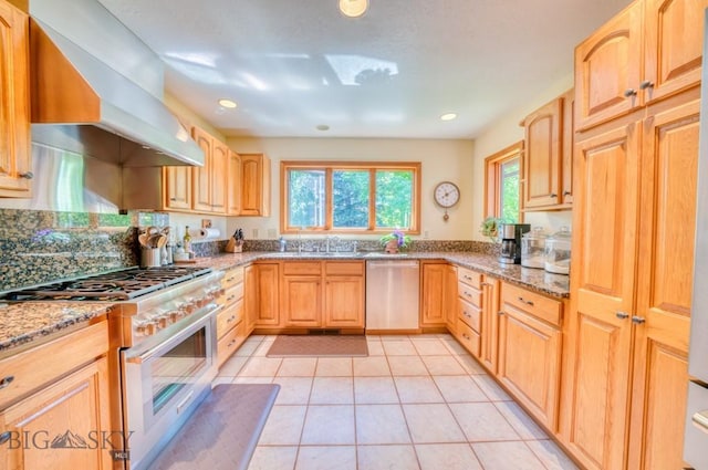 886 Wierda Way, Manhattan, MT 59741 - kitchen featuring stainless steel appliances, wall chimney range hood, light stone counters, light tile patterned floors, and recessed lighting