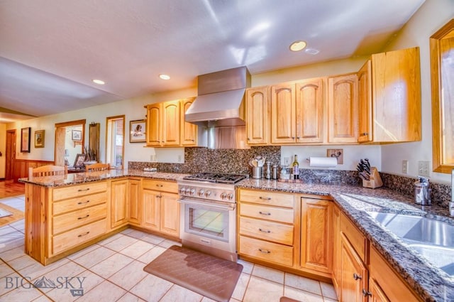 886 Wierda Way, Manhattan, MT 59741 - kitchen featuring high end stove, wall chimney exhaust hood, a peninsula, light brown cabinetry, and stone countertops