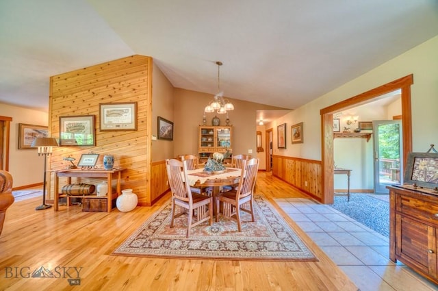 886 Wierda Way, Manhattan, MT 59741 - dining area with lofted ceiling, wooden walls, a chandelier, a wainscoted wall, and wood finished floors
