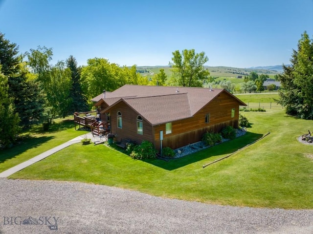 886 Wierda Way, Manhattan, MT 59741 - view of home's exterior with driveway, a shingled roof, a yard, and a deck