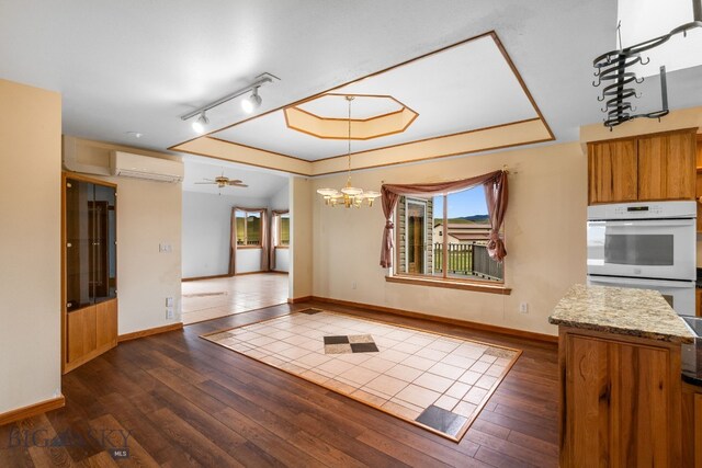 6385 Mt Highway 41, Whitehall, MT 59759 - unfurnished dining area with dark wood-style floors, a wall unit AC, ceiling fan, a chandelier, and track lighting