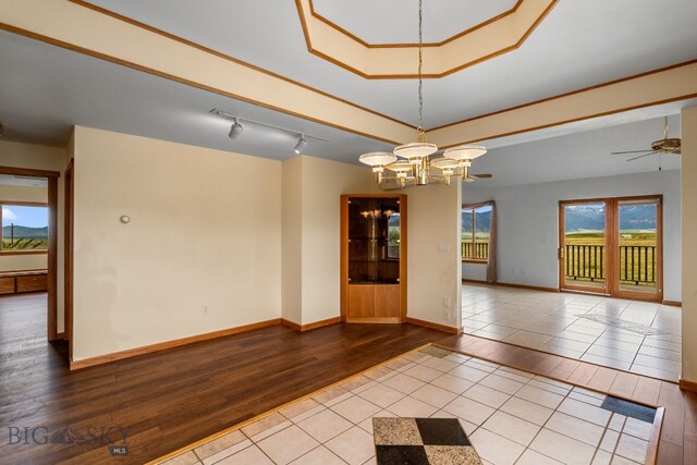6385 Mt Highway 41, Whitehall, MT 59759 - spare room featuring wood finished floors, a chandelier, ceiling fan, a tray ceiling, and rail lighting