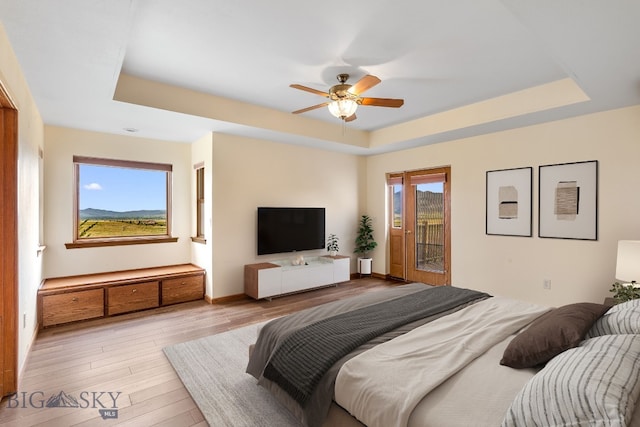 6385 Mt Highway 41, Whitehall, MT 59759 - bedroom with a tray ceiling, access to exterior, light wood-style flooring, and ceiling fan