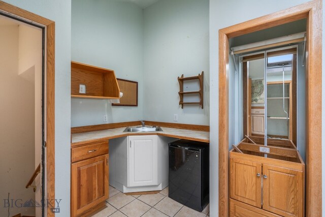 6385 Mt Highway 41, Whitehall, MT 59759 - kitchen with open shelves, light tile patterned flooring, dishwashing machine, tile counters, and white cabinetry