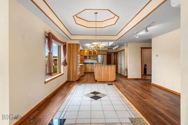 6385 Mt Highway 41, Whitehall, MT 59759 - kitchen featuring wood finished floors, freestanding refrigerator, a chandelier, a kitchen island, and glass insert cabinets