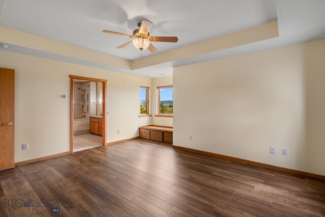 6385 Mt Highway 41, Whitehall, MT 59759 - unfurnished bedroom featuring dark wood-style floors, ensuite bath, and a tray ceiling