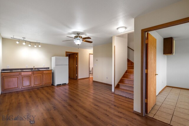 6385 Mt Highway 41, Whitehall, MT 59759 - kitchen with freestanding refrigerator, ceiling fan, wood finished floors, and brown cabinetry