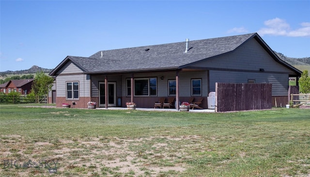 8 Sunset Ct, Ennis, MT 59729 - rear view of house featuring a patio area, roof with shingles, and a mountain view
