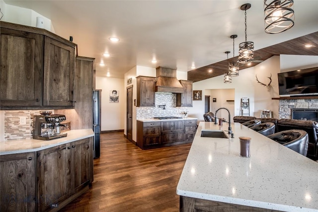 8 Sunset Ct, Ennis, MT 59729 - kitchen with custom exhaust hood, open floor plan, dark brown cabinets, tasteful backsplash, and recessed lighting