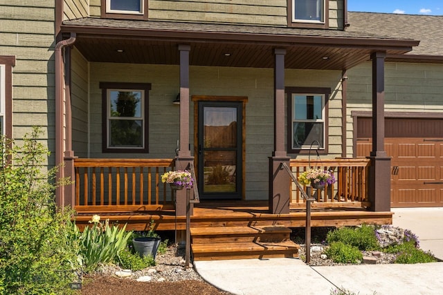 109 Baker St, Belgrade, MT 59714 - view of exterior entry with covered porch, a shingled roof, concrete driveway, and a garage