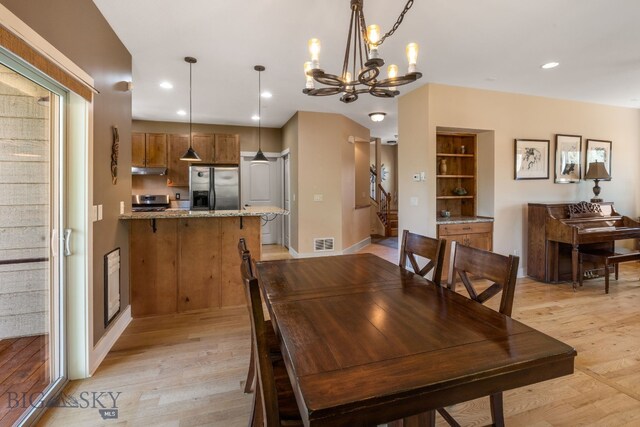 109 Baker St, Belgrade, MT 59714 - dining space featuring light wood finished floors, a chandelier, stairs, and recessed lighting