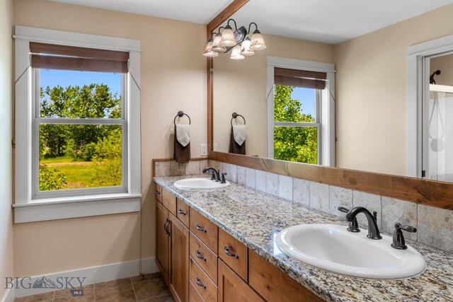 109 Baker St, Belgrade, MT 59714 - bathroom featuring double vanity, tile patterned flooring, and a chandelier