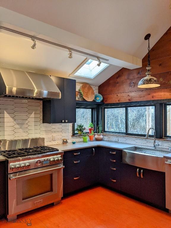 401 S Bozeman Ave, Bozeman, MT 59715 - kitchen featuring stainless steel gas range oven, a skylight, wall chimney range hood, light countertops, and decorative backsplash