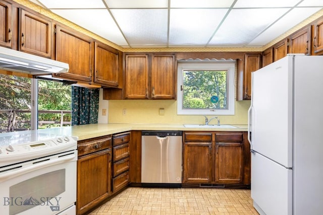 117 Henderson St, Bozeman, MT 59715 - kitchen featuring white appliances, light countertops, brown cabinetry, and under cabinet range hood