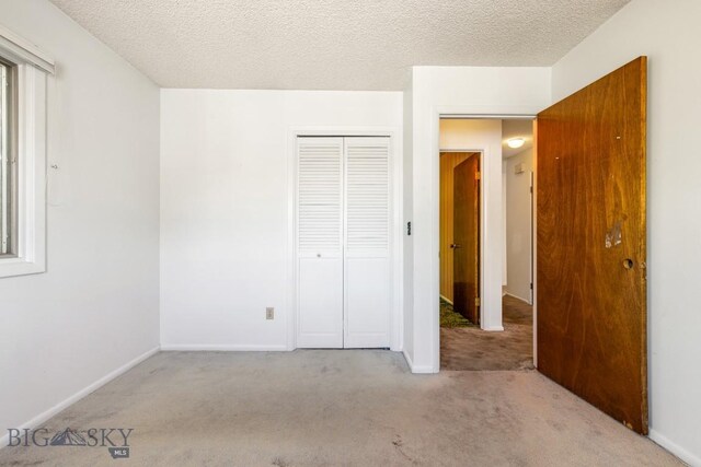 117 Henderson St, Bozeman, MT 59715 - unfurnished bedroom with carpet, a closet, and a textured ceiling