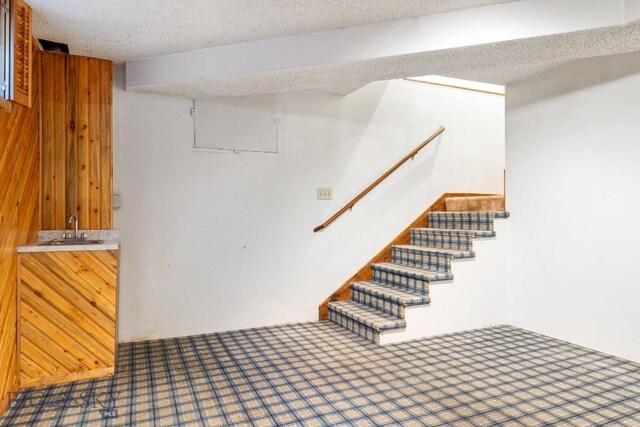 117 Henderson St, Bozeman, MT 59715 - finished basement featuring wet bar, stairway, wood walls, and a textured ceiling